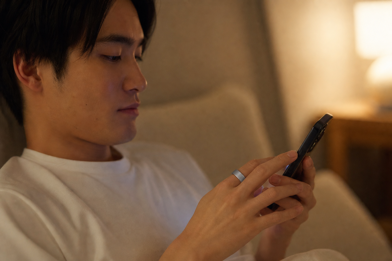 スマートフォンで通販アプリを操作するスマートリング装着の手元