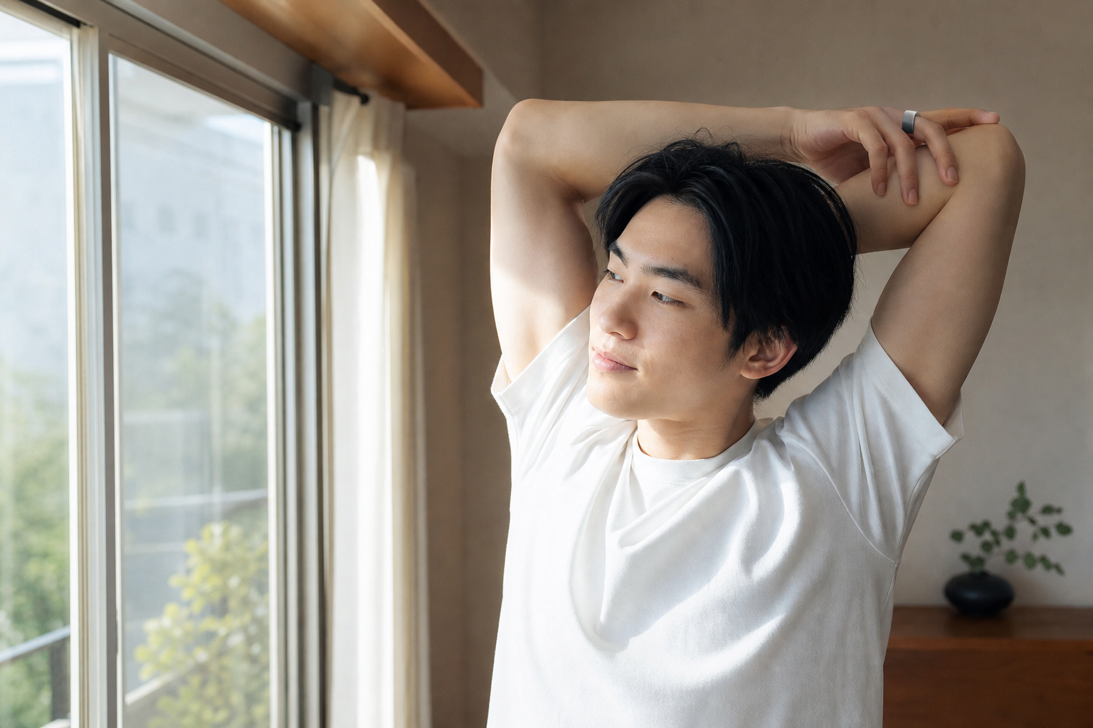 朝の窓辺でリングを着けたまま軽くストレッチする人物